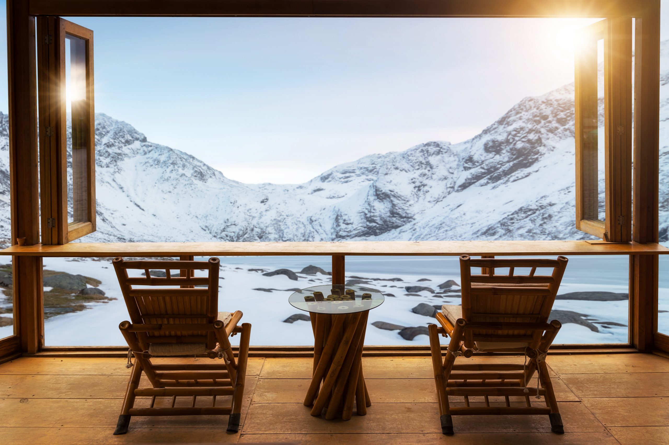 Beautiful landscape at cafe style minimal with wood tables and chairs terrace against the outdoor Mountain view in cafe at sunrise.